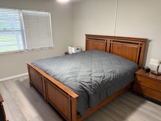 bedroom with light wood finished floors and baseboards