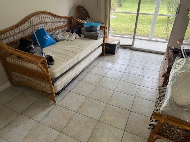 bedroom with light tile patterned floors and access to outside