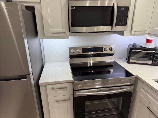 kitchen with white cabinetry and stainless steel appliances