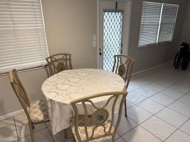 dining space featuring light tile patterned flooring and baseboards