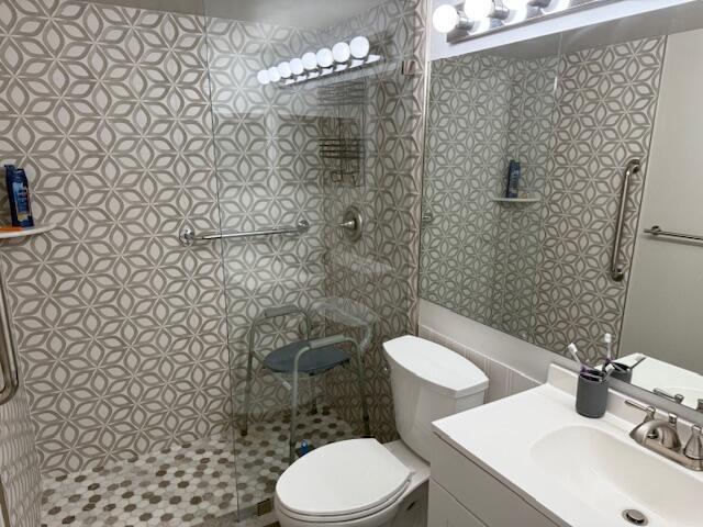 full bath with a shower stall, toilet, and vanity