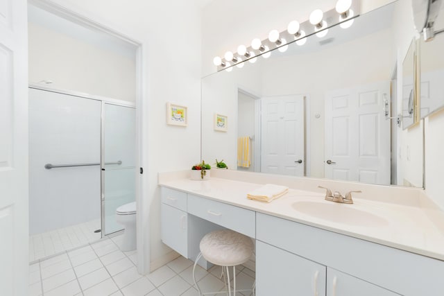 full bathroom with vanity, toilet, tile patterned flooring, and a tile shower