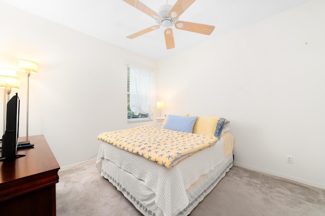 carpeted bedroom with ceiling fan and baseboards