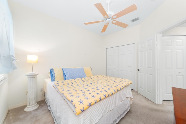 bedroom with visible vents, baseboards, light colored carpet, and a ceiling fan