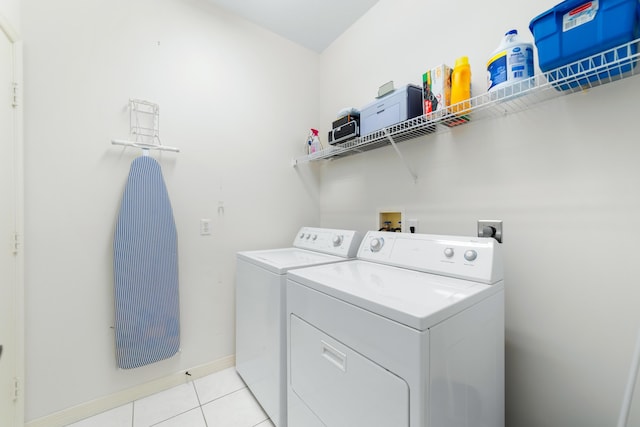 clothes washing area featuring laundry area, light tile patterned floors, baseboards, and independent washer and dryer