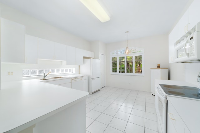 kitchen featuring white appliances, a sink, light countertops, white cabinetry, and a chandelier