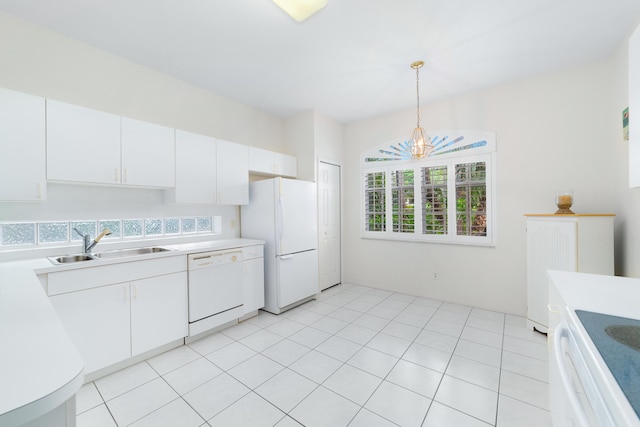 kitchen featuring white appliances, pendant lighting, light countertops, and a sink