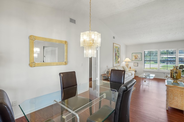 dining space featuring wood finished floors, visible vents, baseboards, lofted ceiling, and a textured ceiling