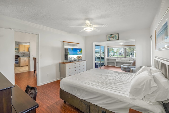 bedroom featuring a ceiling fan, wood finished floors, baseboards, and a textured ceiling