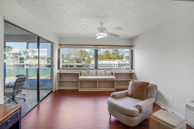 sunroom with a water view and ceiling fan