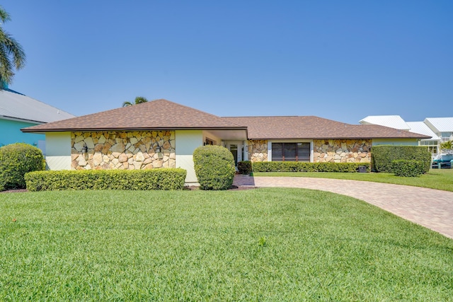 view of front of house featuring a front lawn and stone siding