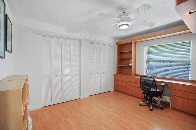 office featuring ceiling fan, light wood-style floors, and a textured ceiling