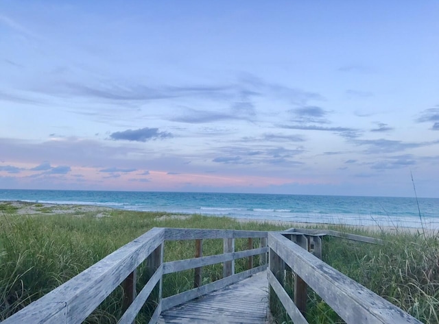 surrounding community featuring a beach view and a water view