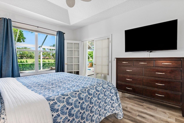 bedroom with light wood-style floors, access to exterior, a ceiling fan, and a textured ceiling