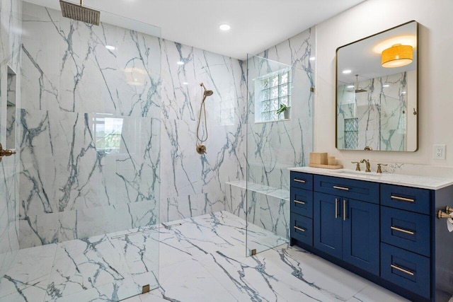 full bath with a marble finish shower, marble finish floor, stone wall, and vanity