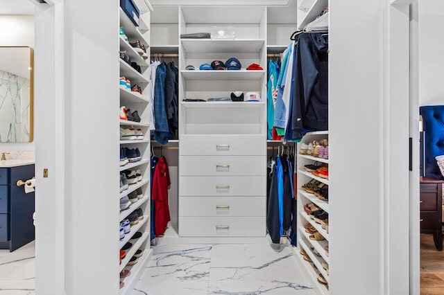 spacious closet featuring marble finish floor and a sink