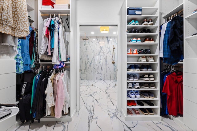 walk in closet featuring marble finish floor