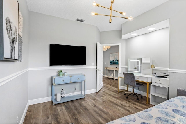 bedroom featuring a notable chandelier, wood finished floors, visible vents, and baseboards