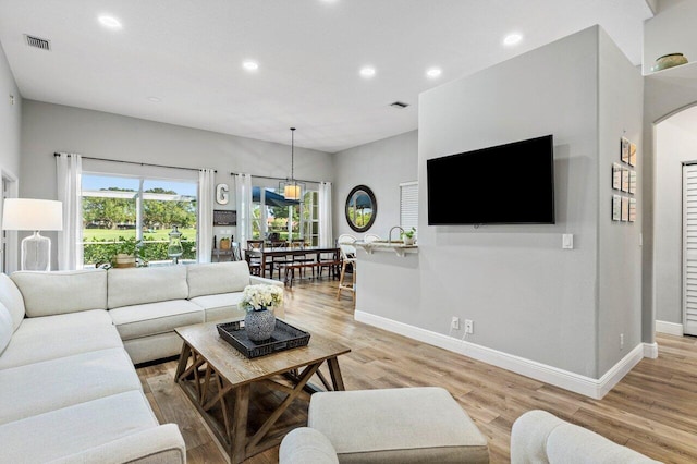 living area featuring recessed lighting, baseboards, and light wood-style floors