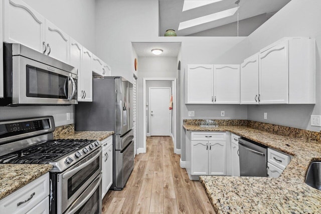 kitchen featuring light wood-type flooring, stainless steel appliances, baseboards, white cabinets, and light stone countertops