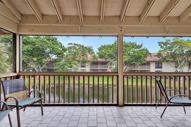 unfurnished sunroom featuring beamed ceiling