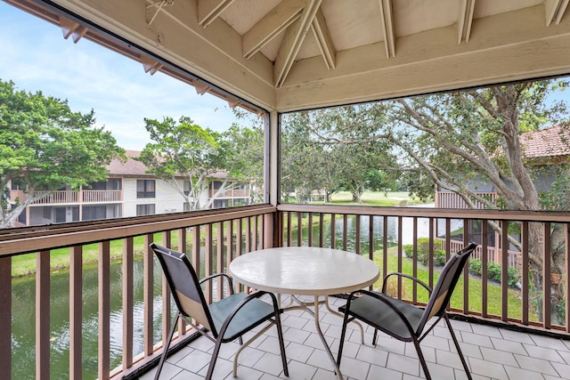 balcony featuring outdoor dining space and a water view