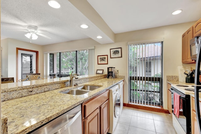 kitchen with light stone counters, washer / dryer, a sink, stainless steel dishwasher, and white electric range