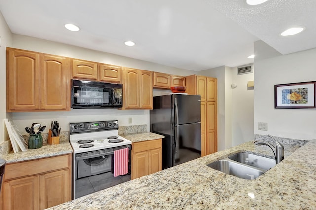 kitchen with visible vents, light stone countertops, recessed lighting, black appliances, and a sink