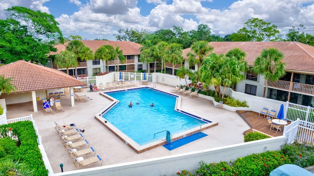 pool with a patio area and fence