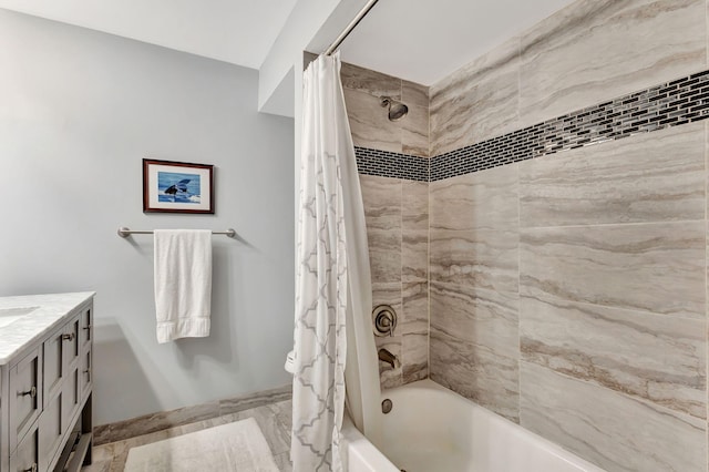 full bath with marble finish floor, vanity, shower / tub combo with curtain, and baseboards