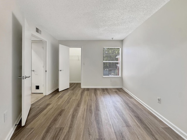1335 Crystal Way Unit L, Delray Beach, FL 33444 - unfurnished bedroom with a textured ceiling, wood finished floors, baseboards, and a closet