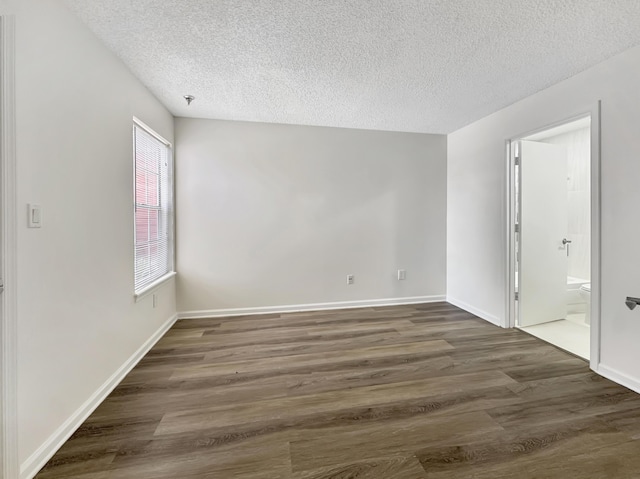 1335 Crystal Way Unit L, Delray Beach, FL 33444 - spare room featuring a textured ceiling, dark wood-type flooring, baseboards, and a pendent fire sprinkler