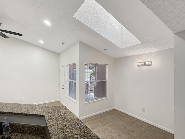1335 Crystal Way Unit L, Delray Beach, FL 33444 - tiled spare room with a textured ceiling, a skylight, vaulted ceiling, a ceiling fan, and recessed lighting
