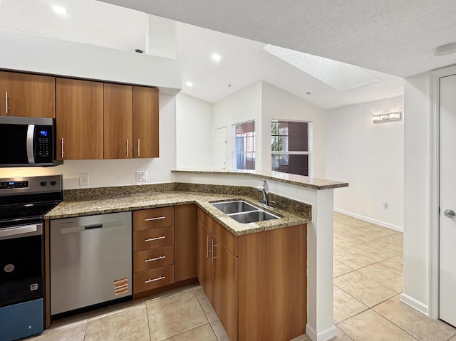 1335 Crystal Way Unit L, Delray Beach, FL 33444 - kitchen featuring stainless steel appliances, a sink, a peninsula, brown cabinets, and lofted ceiling