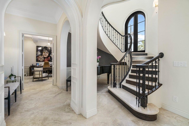 interior space with arched walkways, stairway, baseboards, and ornamental molding