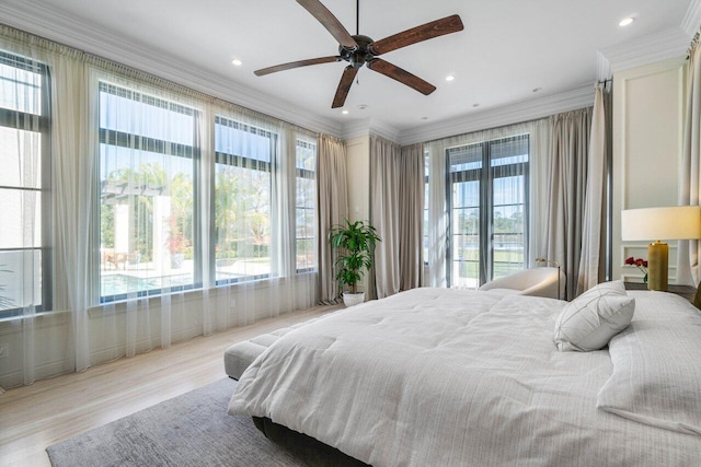 bedroom with multiple windows, crown molding, and wood finished floors