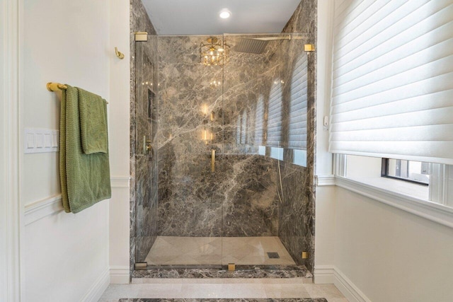 bathroom featuring a marble finish shower and baseboards