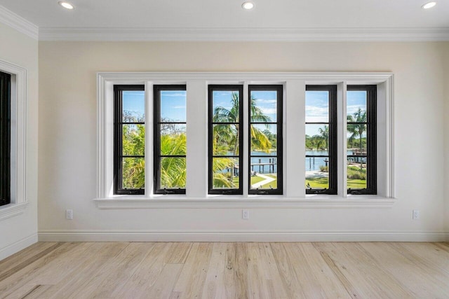 empty room with recessed lighting, wood finished floors, baseboards, and ornamental molding