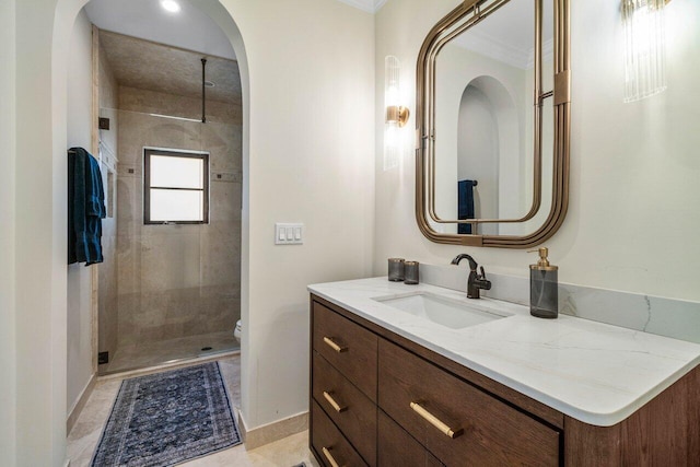 bathroom with vanity, toilet, baseboards, and a stall shower