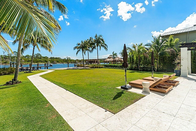 view of property's community with a lawn and a water view