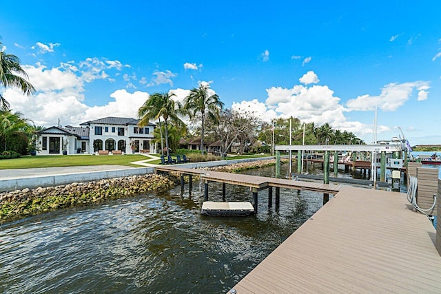 view of dock featuring a yard, a water view, and boat lift