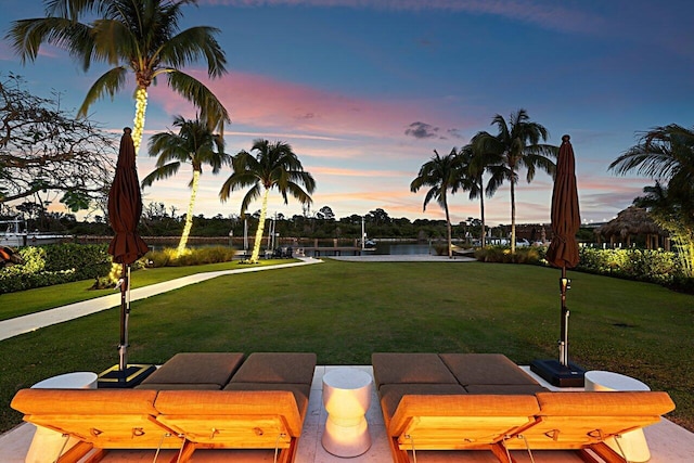 yard at dusk featuring a water view