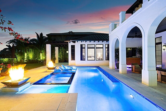 view of swimming pool featuring a patio, a fire pit, and a pool with connected hot tub