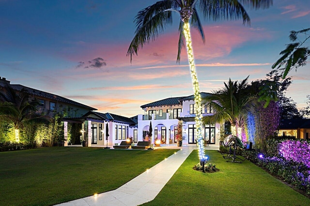 view of front of home with french doors and a front lawn