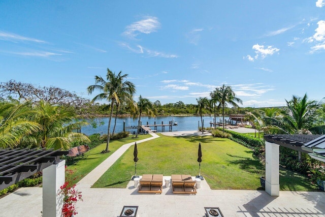 view of property's community with a yard, a water view, boat lift, and a dock