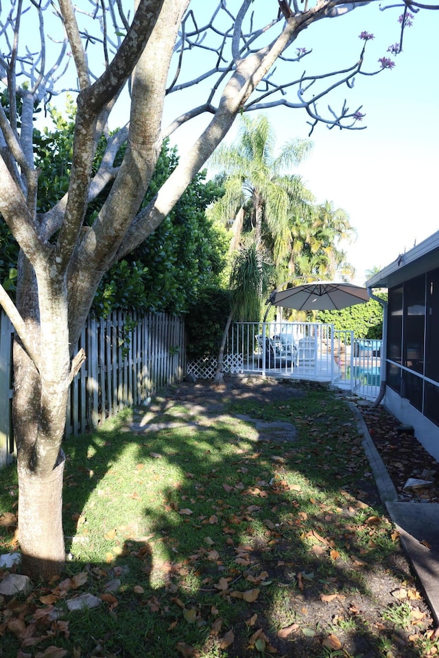 view of yard featuring fence and a sunroom