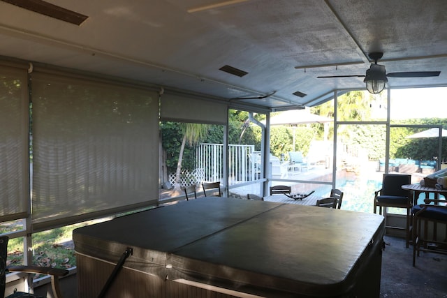 unfurnished sunroom featuring ceiling fan