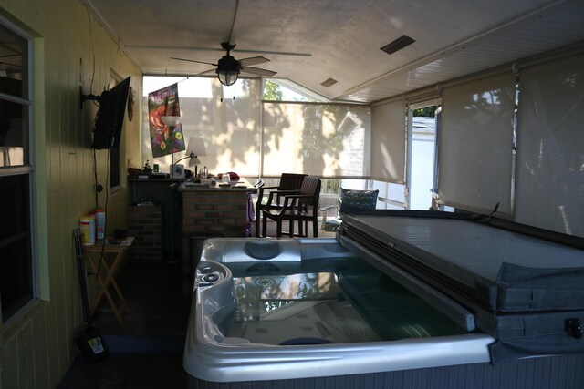 sunroom with a jacuzzi, a ceiling fan, and visible vents