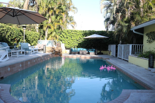 view of swimming pool with a fenced in pool, fence, an outdoor living space, area for grilling, and a patio area