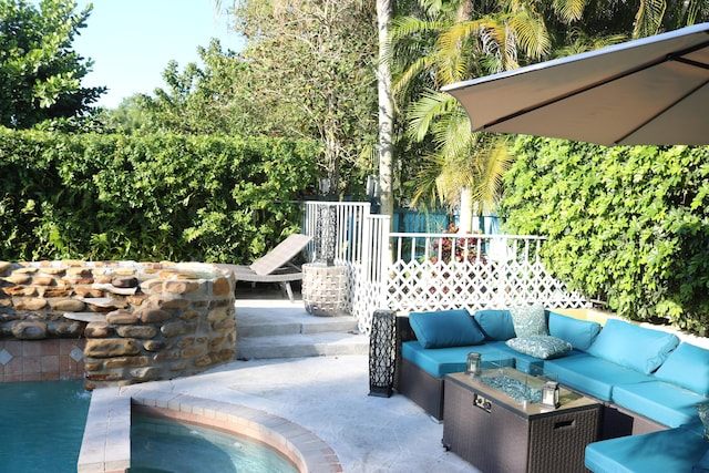 view of patio featuring an outdoor living space with a fire pit and fence